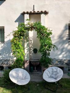 two white chairs in front of a building at Appartamento LaLieve - casaDELRESTO in Gaiola