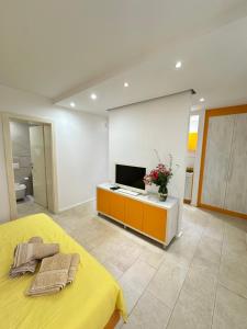 a bedroom with a yellow bed and a television at Apartments Karmen Maria in Novigrad Istria +178 photos