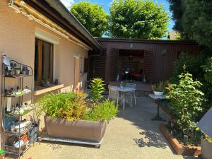 a backyard with a patio with plants and a table at LE ROSSIGNOL in Cranves-Sales