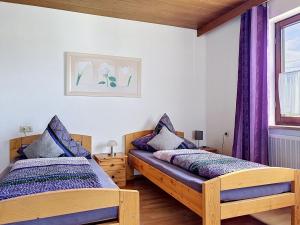 two beds in a room with purple curtains at Apartment Sirch-2 by Interhome in Diedorf