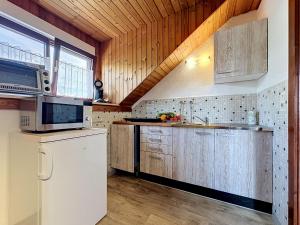 a kitchen with wooden cabinets and a white refrigerator at Apartment Sirch-3 by Interhome in Diedorf