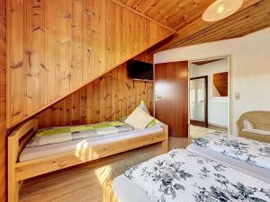two beds in a room with wooden walls at Apartment Sirch-3 by Interhome in Diedorf