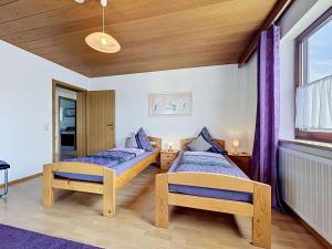 two beds in a room with purple curtains at Apartment Sirch-4 by Interhome in Diedorf