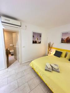 a bedroom with a yellow bed with towels on it at Apartments Karmen Maria in Novigrad Istria