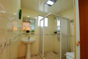 un bagno con lavandino e doccia di Greenown B&B a Yuanshan
