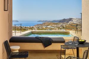 a view of a swimming pool from a balcony with a table at Enorme EOS Santorini - Adults Only in Pyrgos