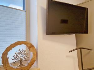 a flat screen tv hanging on a wall next to a mirror at Apartment A3 by Interhome in Kematen in Tirol