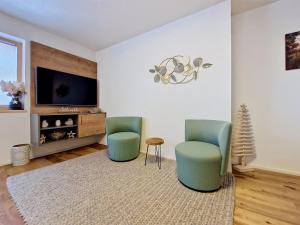 a living room with two chairs and a tv at Apartment A3 by Interhome in Kematen in Tirol