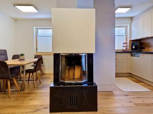 a fireplace in a living room with a table at Apartment A3 by Interhome in Kematen in Tirol