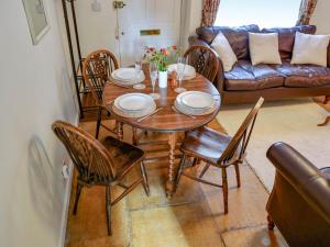 a wooden table and chairs in a living room at Pam's Cottage in Cheltenham