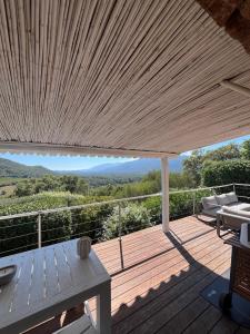 a wooden deck with a bench and a table at Torraccia in Porto-Vecchio