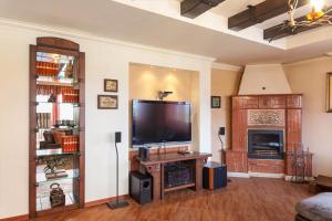 a living room with a large television and a fireplace at Любомировата къща in Sredni Kolibi