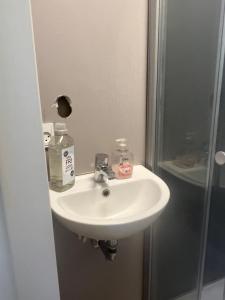 a bathroom with a white sink and a shower at Thistedvej 40 in Nørresundby