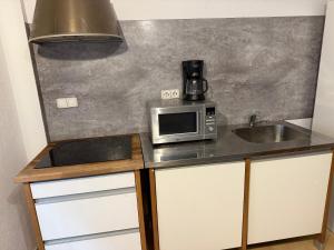 a kitchen with a sink and a microwave on a counter at Lupe Mediterranean Loft,150m from the Beach Blanes Center in Blanes