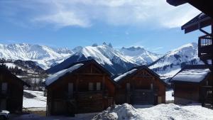 a group of cabins in the snow with mountains at Studio plein sud avec piscine in Saint-Jean-dʼArves
