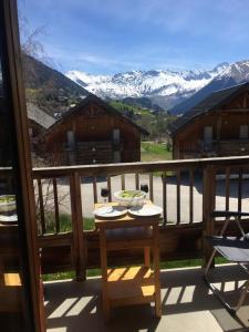 a table on a balcony with a view of mountains at Studio plein sud avec piscine in Saint-Jean-dʼArves