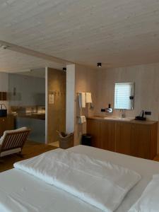 a bedroom with a white bed and a kitchen at 2ND HOME HOTEL - Ihr 4 Sterne Hotel in Nördlingen als zweites Zuhause in Nördlingen +72 photos