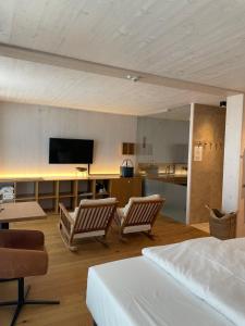 a room with two chairs and a tv and a kitchen at 2ND HOME HOTEL - Ihr 4 Sterne Hotel in Nördlingen als zweites Zuhause in Nördlingen