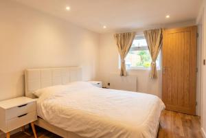 a bedroom with a white bed and a window at Garden Studio in Hove, Parking & Hot Tub in Brighton & Hove