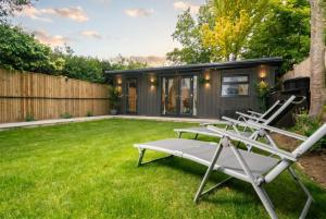 a backyard with a tiny house at Garden Studio in Hove, Parking & Hot Tub in Brighton & Hove +32 photos