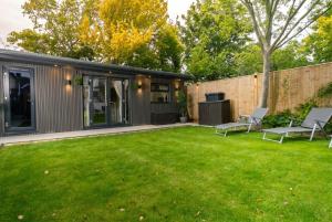 a backyard with green grass and a house at Garden Studio in Hove, Parking & Hot Tub in Brighton & Hove
