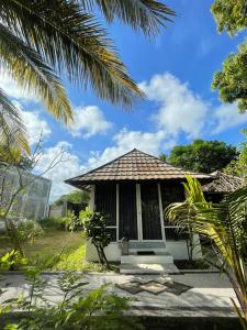 a small house with a thatched roof at Selong Belanak Bungalows in Selong Belanak +30 photos