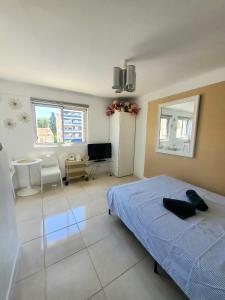 a bedroom with a bed and a room with a tv at Cannes Centre Studio Lumineux et Chic, à 9 Min à Pied du Palais des Festivals et des Plages, Clim in Cannes