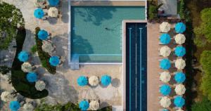 an overhead view of a swimming pool with blue umbrellas at Camping Union Lido in Cavallino-Treporti
