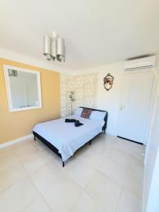 a bedroom with a bed and a white tile floor at Cannes Centre Studio Lumineux et Chic, à 9 Min à Pied du Palais des Festivals et des Plages, Clim in Cannes