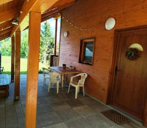 a wooden patio with a wooden table and chairs at Romantic cabin in the woods - Fesnga, Slovenia in Slovenj Gradec +39 photos