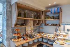 a kitchen with a counter with plates and wine bottles at Volta Seaside Boutique Hotel in Kokkini Khanion