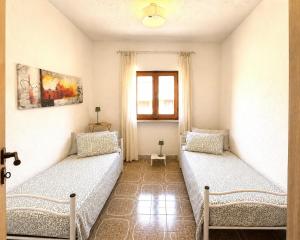 a room with two beds and a window at Villa nel centro di Palau in Palau