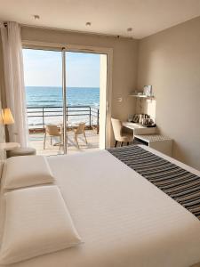 a bedroom with a bed and a view of the ocean at Hôtel Valencia in Hendaye