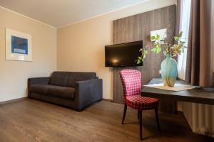 a living room with a couch and a table and a chair at Hotel Staffler in Odelzhausen