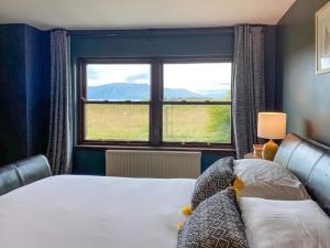 a bedroom with a bed and a large window at Ardtur Croft in Appin