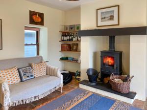 a living room with a couch and a fireplace at Ardtur Croft in Appin