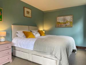 a bedroom with a white bed with yellow pillows at Ardtur Croft in Appin +9 photos