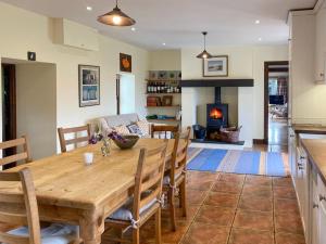 a dining room with a wooden table and a fireplace at Ardtur Croft in Appin