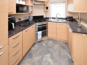a kitchen with a sink and a stove top oven at Fellside Lodge in Cockermouth