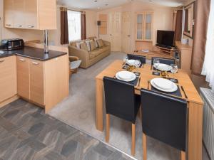 a kitchen and living room with a table and chairs at Fellside Lodge in Cockermouth