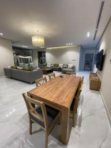 a living room with a wooden table and a couch at Villa with private Pool A in Al Khīrān