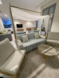 a living room with white couches and a tv at Villa with private Pool A in Al Khīrān