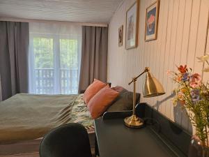 a bedroom with a bed and a desk with a lamp at Leśne zacisze - dom z kominkiem i balią in Jordanów
