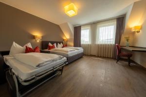 a hotel room with two beds and a desk at Hotel Staffler in Odelzhausen +56 photos