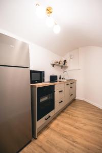 a kitchen with a refrigerator and a sink at Le Cocopop in Dinant
