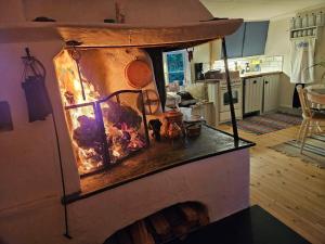a fireplace in a kitchen with a fire in it at Tolvmansgården in Enköping