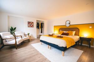a bedroom with a large bed with a yellow wall at Le Cocopop in Dinant