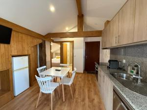 a kitchen with a table and chairs and a sink at Porta 4 City Flat in Vila Real