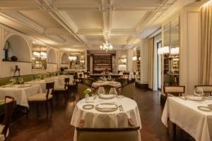 a dining room with tables and chairs with white tablecloths at Corinthia Rome in Rome