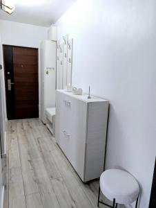 a white bathroom with a sink and a chair at Ariana Urban Loft in Târgu-Mureş +15 photos